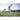 Soccer player practices dribbling around yellow poles on a grassy field during training