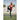 Woman exercises with resistance bands on outdoor sports field during daytime