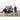 Man practices balancing drills with a weighted bag on a sports field while others observe