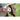 Person holds two baseballs in front of a glove outdoors on grass field