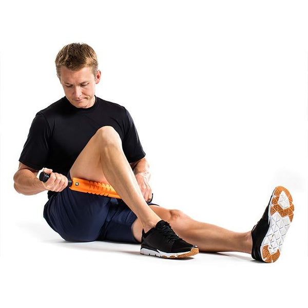 "A man uses the TriggerPoint GRID STK® Foam Roller Massage Tool on bench to achieve acupressure relief on his leg."