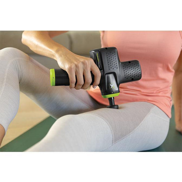 Woman using the TriggerPoint percussion massage gun recover faster pre- and post- workout.