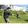 Man's hitting a yellow SKLZ Foam Training Ball with a baseball bat with a friend in the backyard.