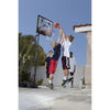 Kids playing with SKLZ's black basketball system in a front yard of a house